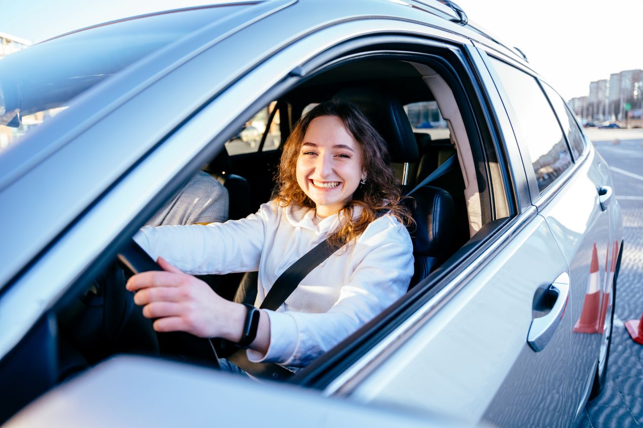 Eine junge Fahrerin sitzt fröhlich im Auto bei einem Fahrsicherheitstraining – praktische Erfahrungen aus den WAB Kurse Zürich.