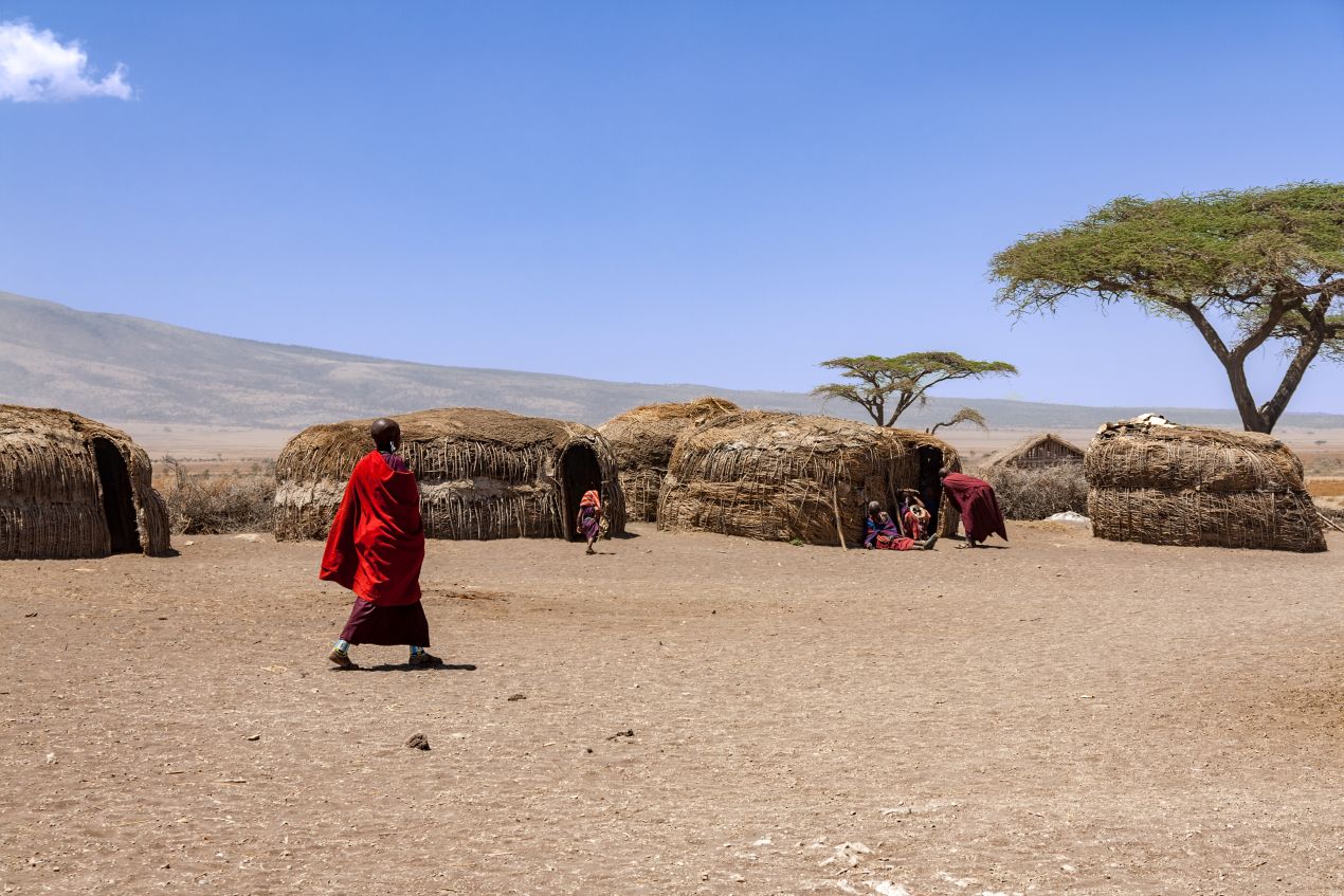 Massai-Dorf mit Strohhütten in Tansania, umgeben von offener Savanne – ein kulturelles Highlight jeder Tansania Safari