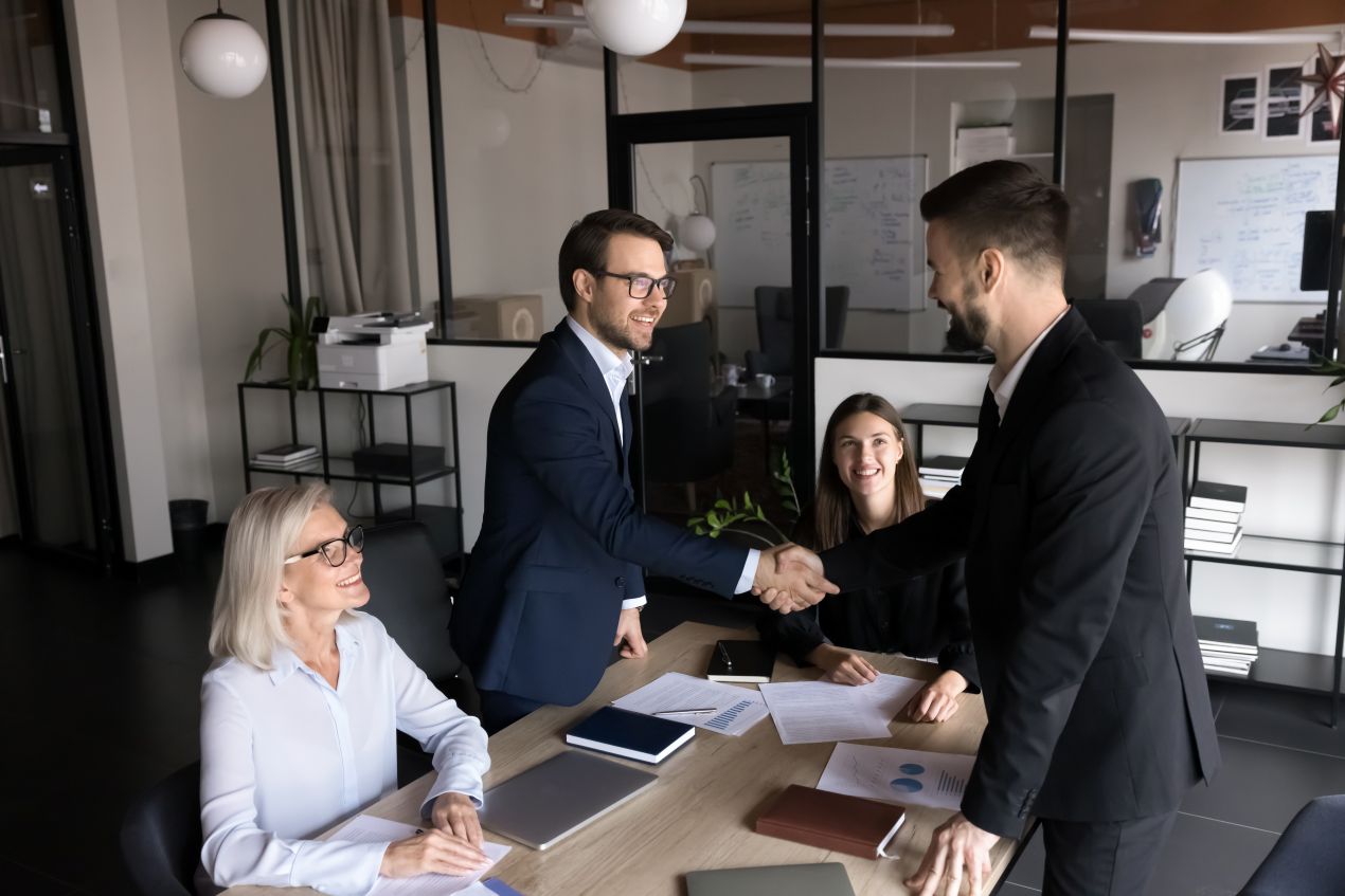 Geschaeftspartner beim Handschlag nach erfolgreichem Meeting mit kundengeschenke Strategie