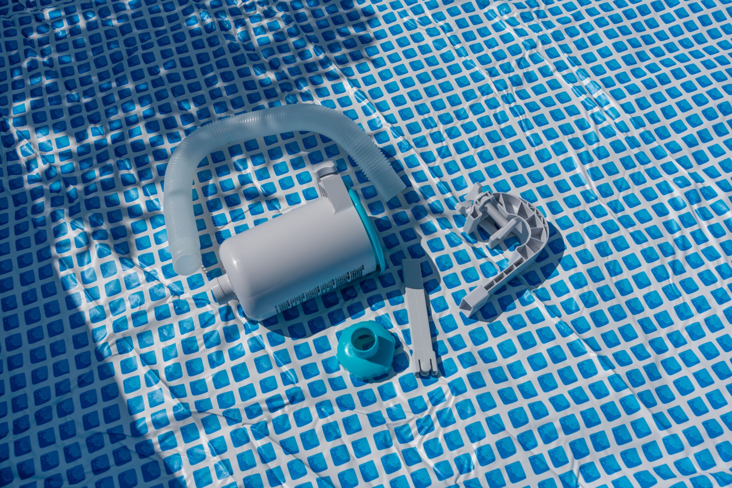 Einzelteile eines Pool Komplettset liegen im leeren Aufstellpool vor dem Zusammenbau