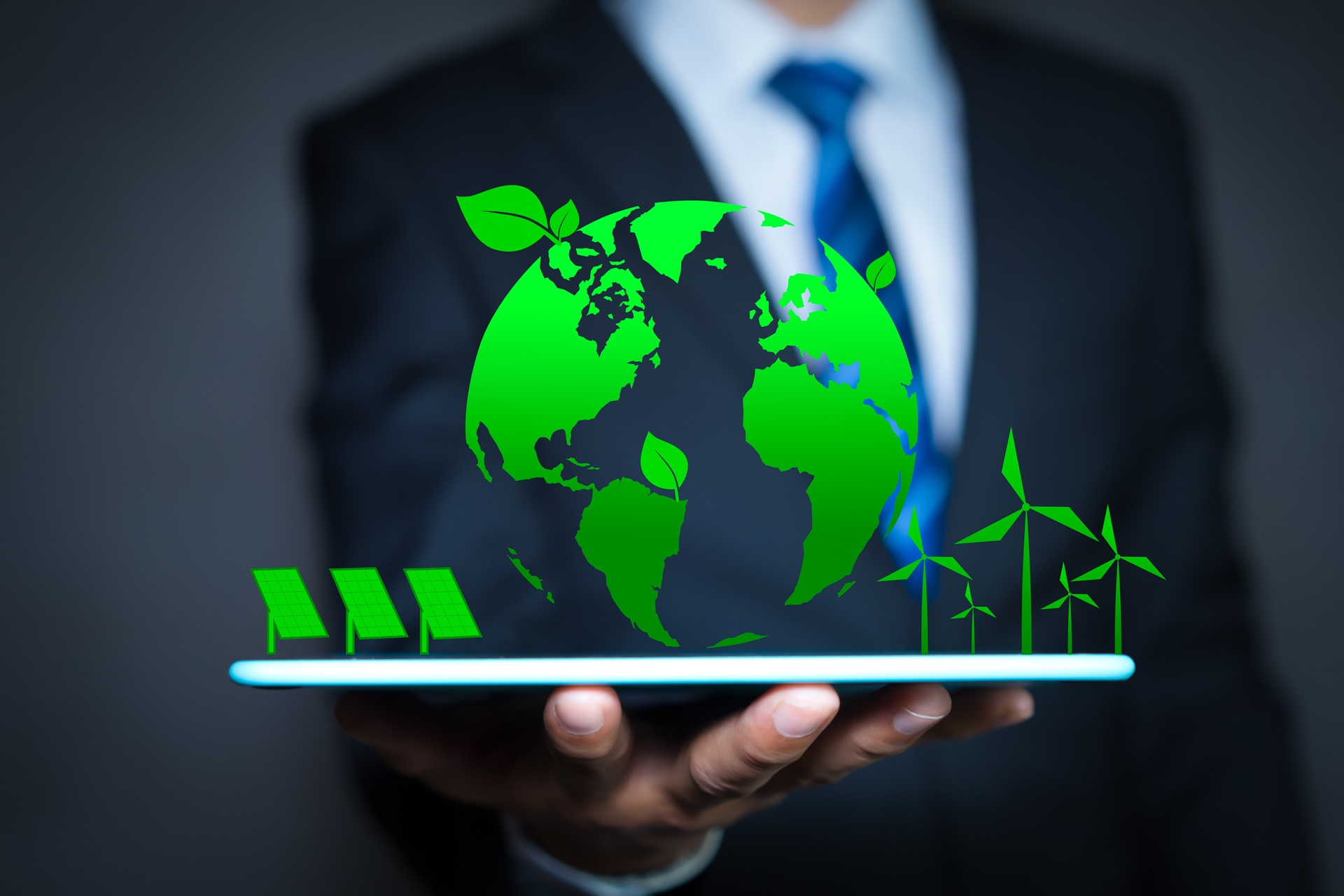 Geschäftsmann hält digitale grüne Weltkugel mit Windrädern | Entkalkungsanlage