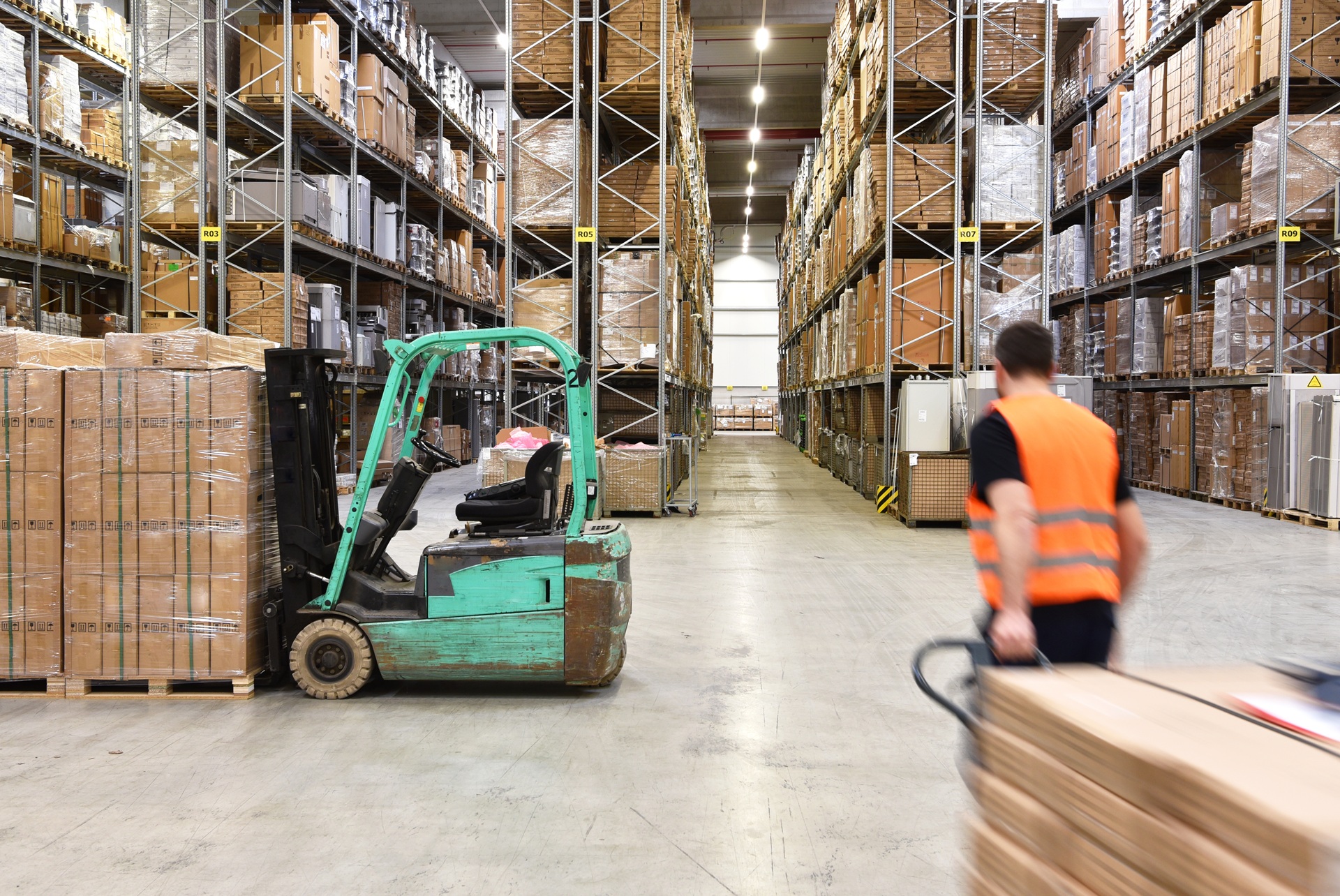Gabelstapler und Mitarbeiter in Lagerhalle | Hochregallager